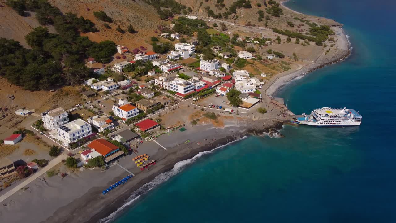 Letecký pohled na malou pobřežní vesnici Agia Roumeli na jižní Krétě, konečný bod túry v rokli Samaria. Trajekt čeká na návrat turistů