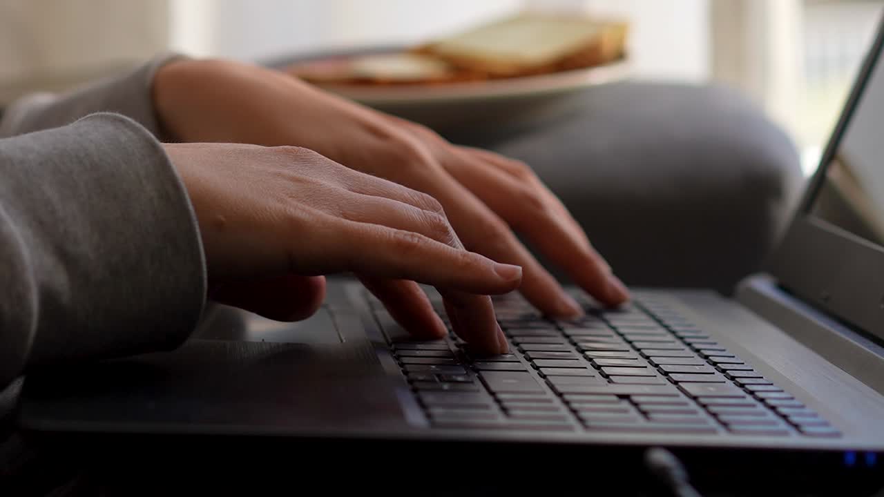 Working from home hand keyboard typing on laptop