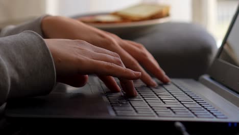 working from home hand keyboard typing on laptop