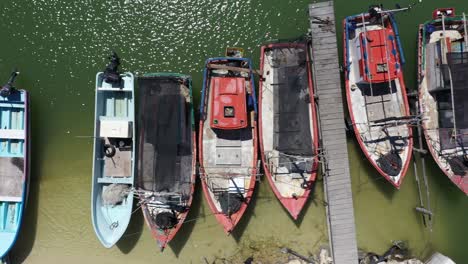 aerial view looking straight down and camera sliding to the left showing small wooden fishing boats in a harbor in mexico