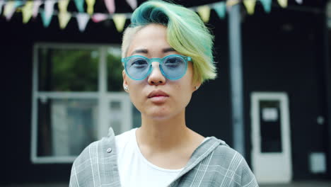 stylish young woman with colorful hair and sunglasses