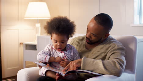 Padre-Leyendo-Un-Libro-A-Su-Hijo-Pequeño-En-Casa-En-La-Guardería