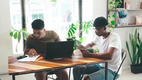 two young men working on a laptop