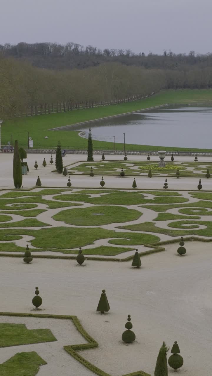 Elegant Versailles garden with geometric hedges and tranquil lake view