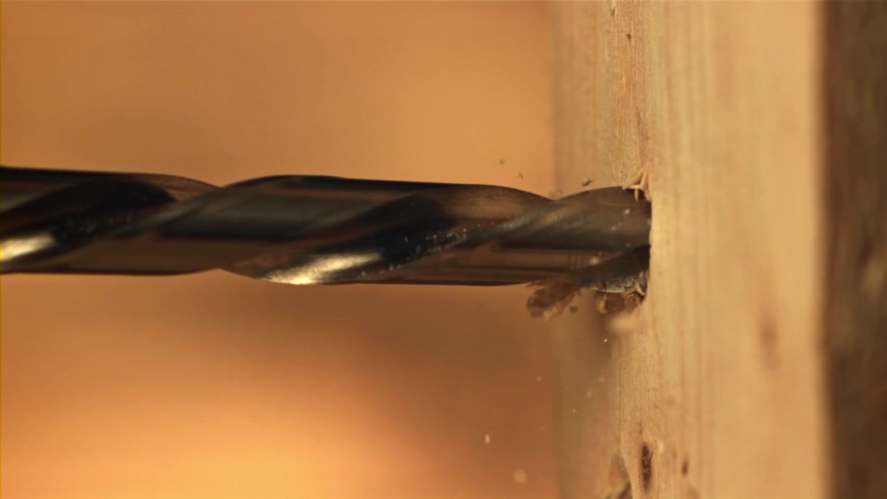 Nahaufnahme eines Bohrers, der in Holz bohrt.