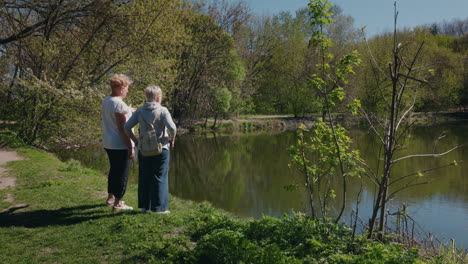 two women enjoying a scenic park with a pond