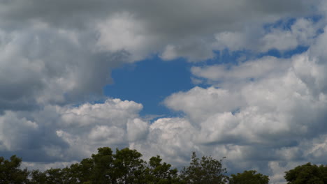 fluffy clouds floating above a forest in realtime.. 4k