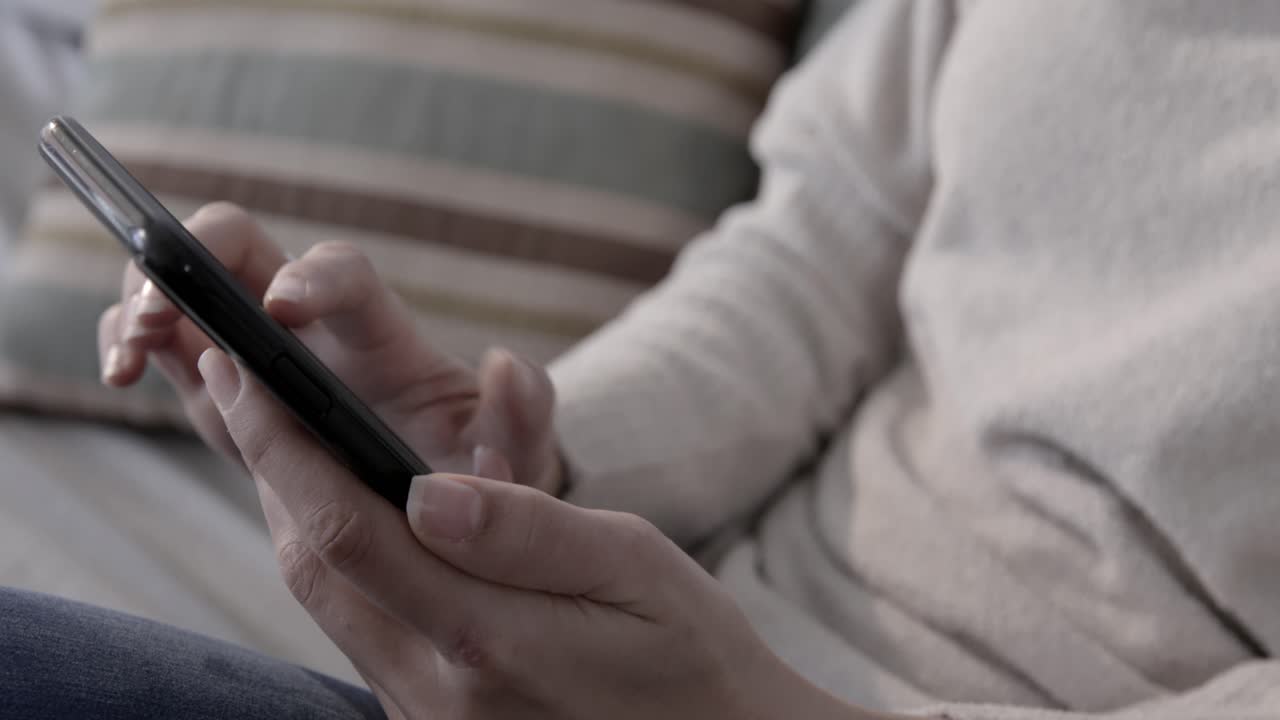 Nærbilde av hender som blar og trykker på en smarttelefonskjerm