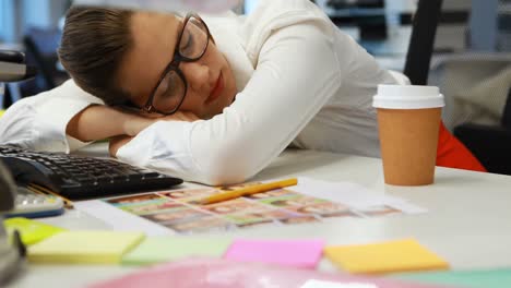 Female-graphic-designer-sleeping-at-desk