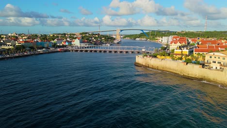 willemstad curacao al atardecer mientras el agua del océano brilla con un velero de mástil en el puerto