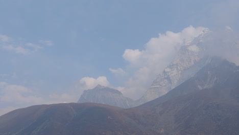 drone shot of dingboche stupa (4400m) with bottom-up view of hills, cloudy skies, and hazy himalayan landscape of everest region in nepal tourism natural view
