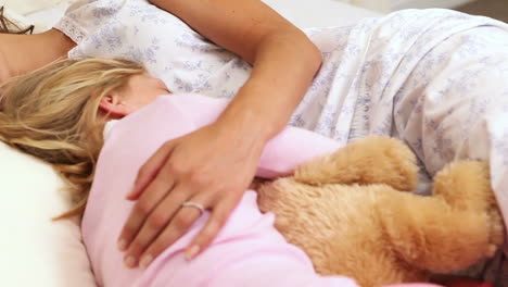 Mother-and-daughter-sleeping-together-in-bed