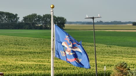 die flagge des staates north dakota schwingt vor einem maisfeld.