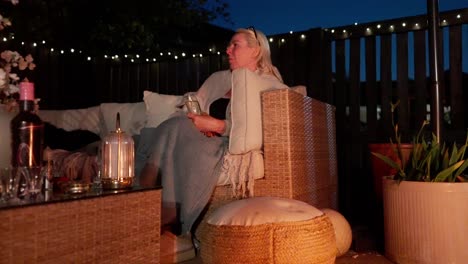 flickering flames illumination, patio warmth, mature drinking female