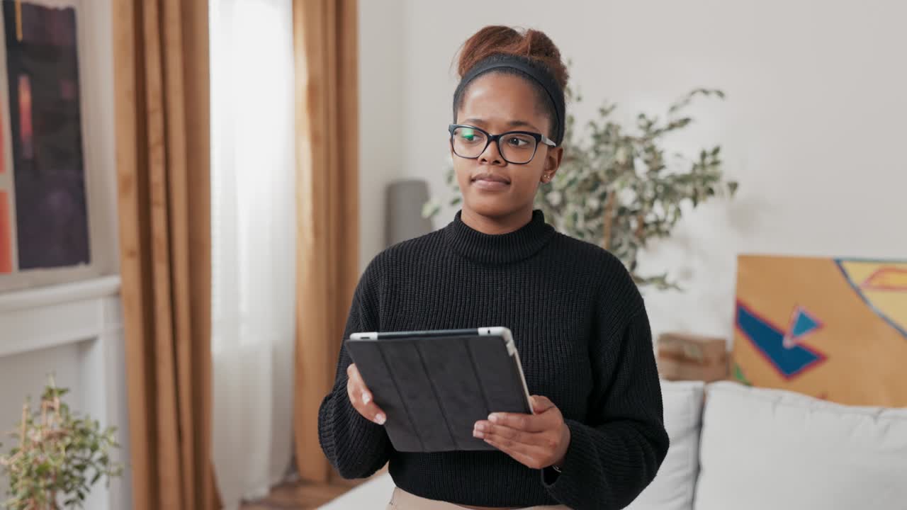 A young girl orders furniture for new apartment online, decorates house after moving in, looks for decorating inspiration, looks around her room, uses tablet