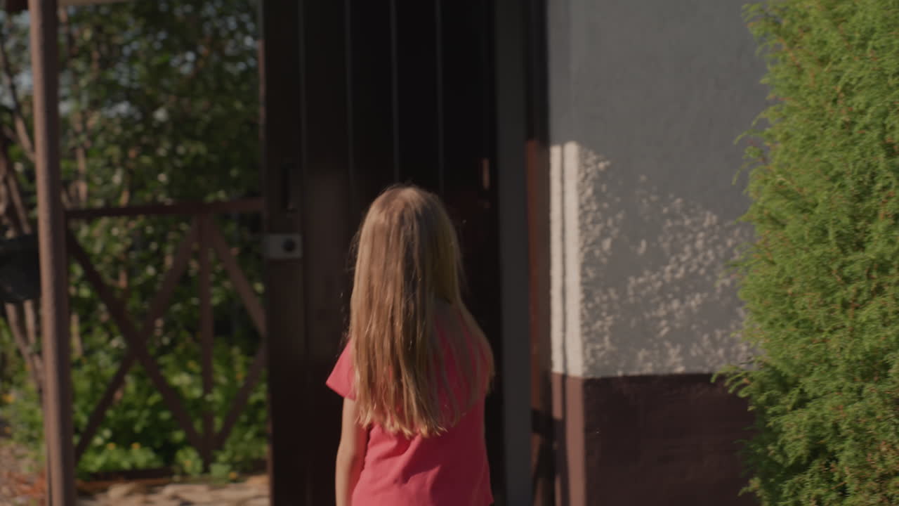 Caucasian Girl Sitting On Wooden Deck Chair In Sunlit Garden, Potted Flowers At Sides And Rustic Cabin Backdrop, Quiet Moment Of Thought Before She Walks Toward Doorway, Warm Golden Light And Calm