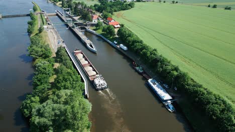 un barco con una carga de arena maniobra lentamente en la esclusa del río