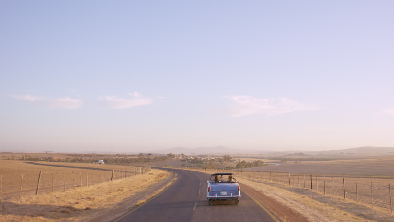 Due amici in road trip all'avventura, alla guida di una decappottabile d'epoca.