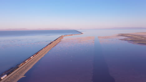 cargo train crossing railroad causeway over great salt lake in utah, usa