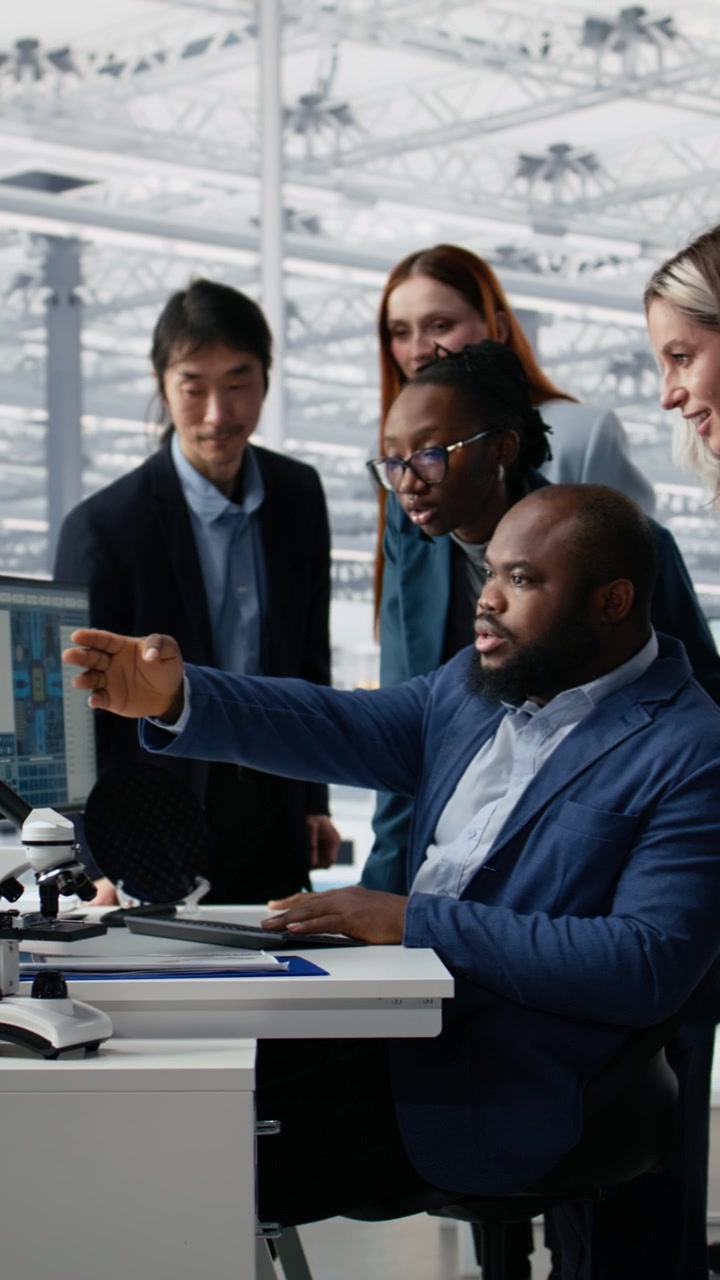 Vertical video Multiracial men and women in microchip factory office working together