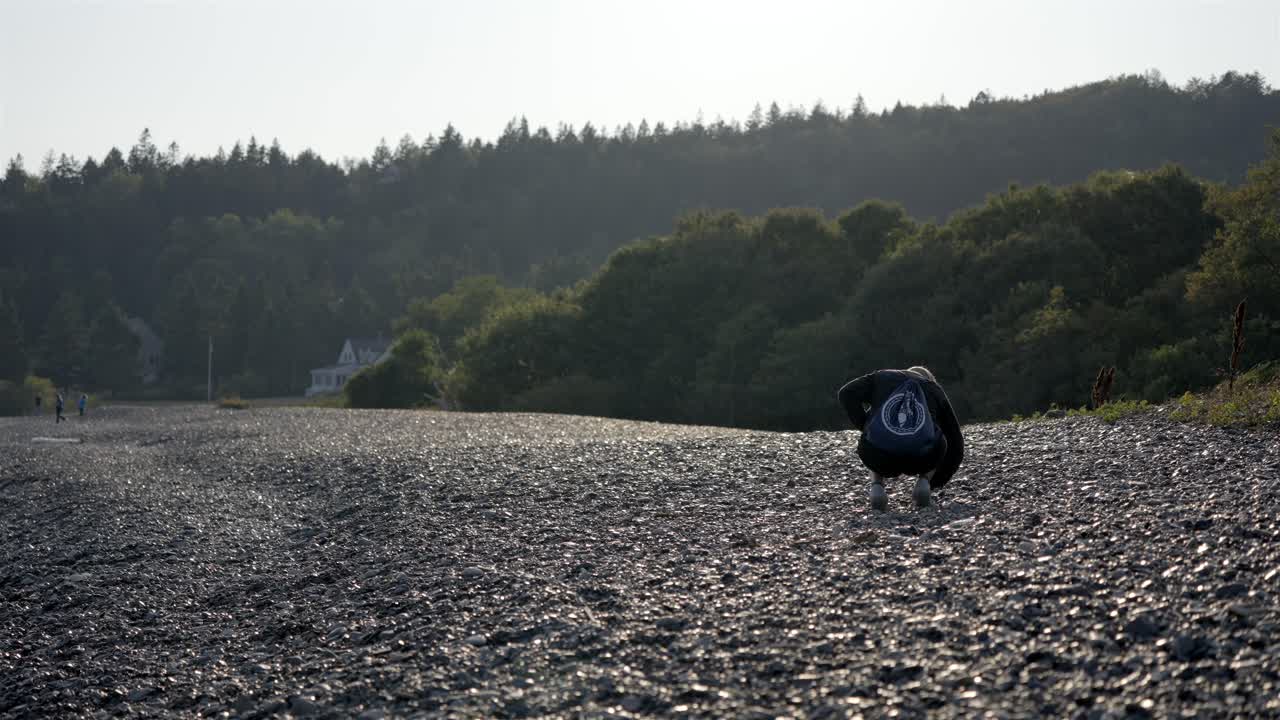 young girl searching for interesting rocks on the famous Jasper Beach, Maine