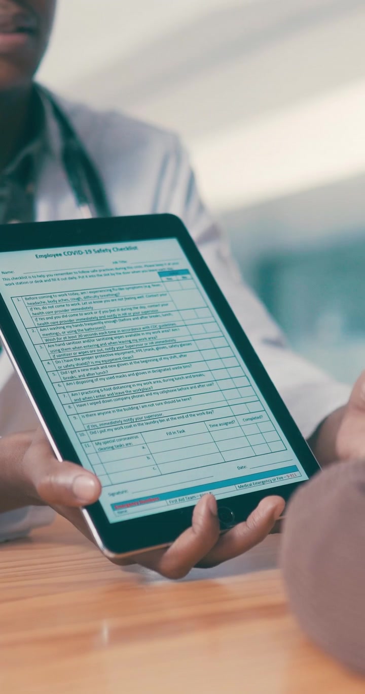 Læge og patient gennemgår digital sundhedstjekliste på tablet