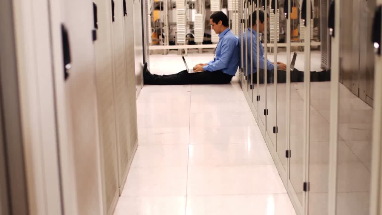 técnico trabajando en una computadora portátil en el pasillo