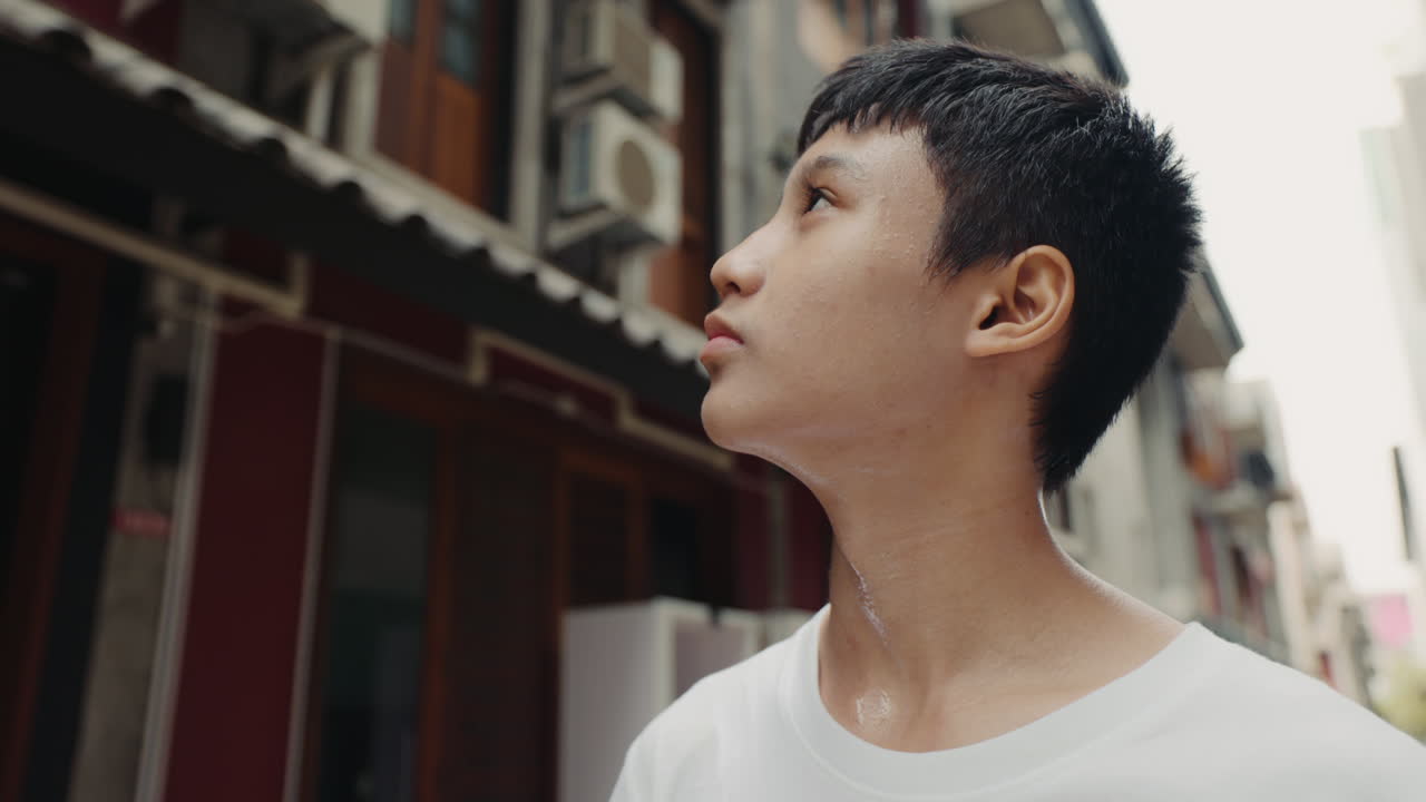 A young person looking up in a city