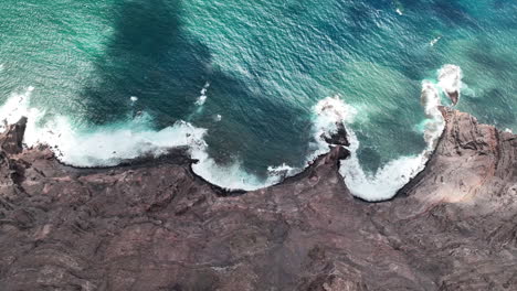 A-high-altitude-aerial-of-a-Canary-Island-coastline,-topview-of-the-300m-cliffs-at-Famara-beach