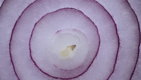 textuur rode ui ringen roterend, close-up top view. geoogst gezonde voedsel achtergrond met groente van rijke vitamine. zoete rode spaanse ui macro shot. voedsel achtergrond close-up gesneden paarse ui