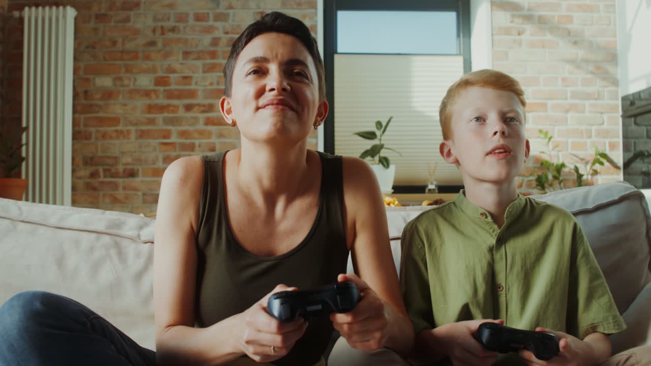 어머니 와 아들 이 비디오 게임 을 하고 있다