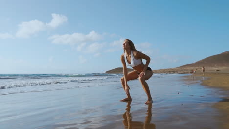 young strong woman in sportswear doing plyometric exercises on pier. jump squats, fitness workout outdoors. slow motion steadicam