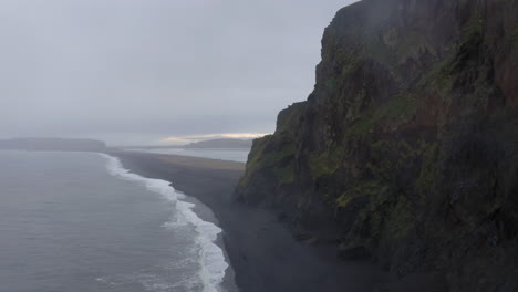 aerial: reynishjara black sand beach in iceland during a rainy day