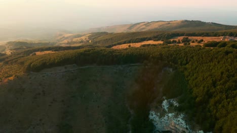 side view of the mountains with beautiful sunrise in summer over lush vegetation at majella national park in abruzzo, italy. - aerial drone shot