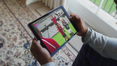 composite of man sitting at home watching rugby match on tablet