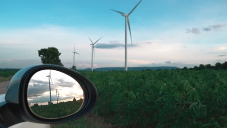 progressive ideal of wind turbine reflected in side mirror of electric vehicle.