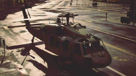 military helicopter parked on a deserted urban street at sunset