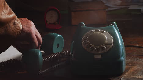 the mysterious person hangs up the receiver and puts it slowly on the table