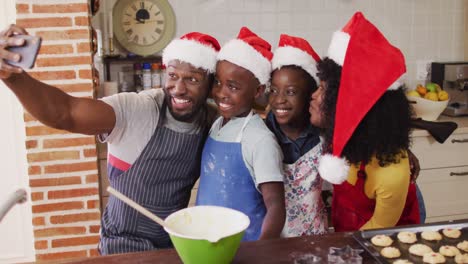 african american family taking a selfie with smartphone while baking