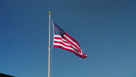 american flag waving against the blue sky