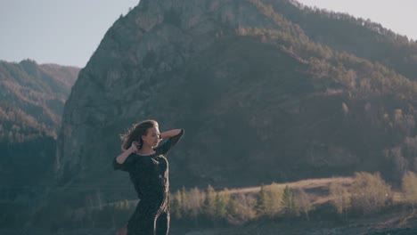 Una-Joven-Con-Un-Vestido-Largo-De-Seda-Se-Opone-A-Las-Montañas