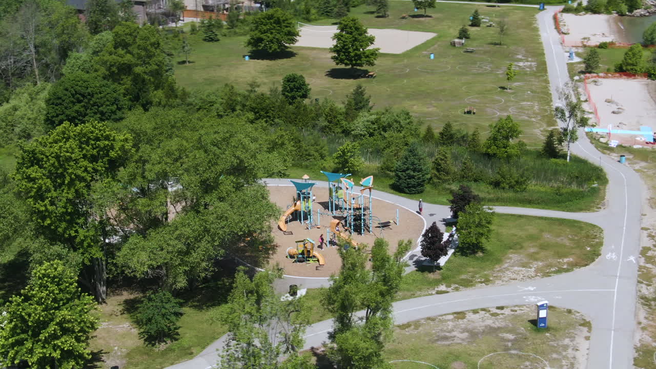 toma de órbita aérea que revela un parque infantil en el parque de la playa de innisfil en la costa del lago simcoe, ontario