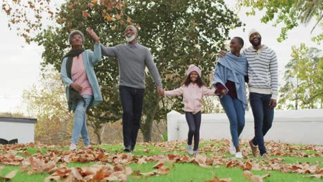 Video-Von-Glücklichen-Afroamerikanischen-Eltern-Und-Großeltern,-Die-Mit-Ihrer-Enkelin-Im-Garten-Spazieren-Gehen