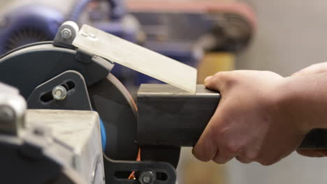 grinding steel tube on a bench grinder, closeup shot