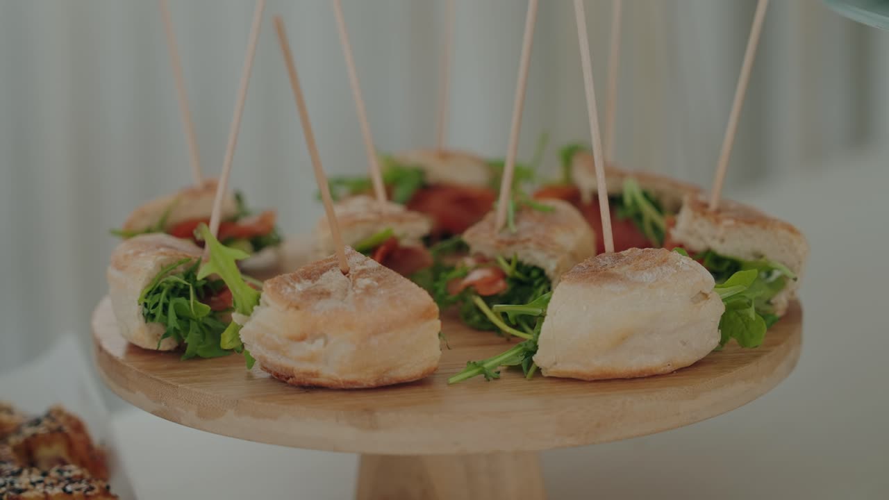 bocadillos en miniatura dispuestos de forma ordenada en una bandeja de madera