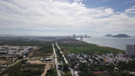 aerial over peninsula mazatlán neighborhood with city, islands, and ocean on the horizon