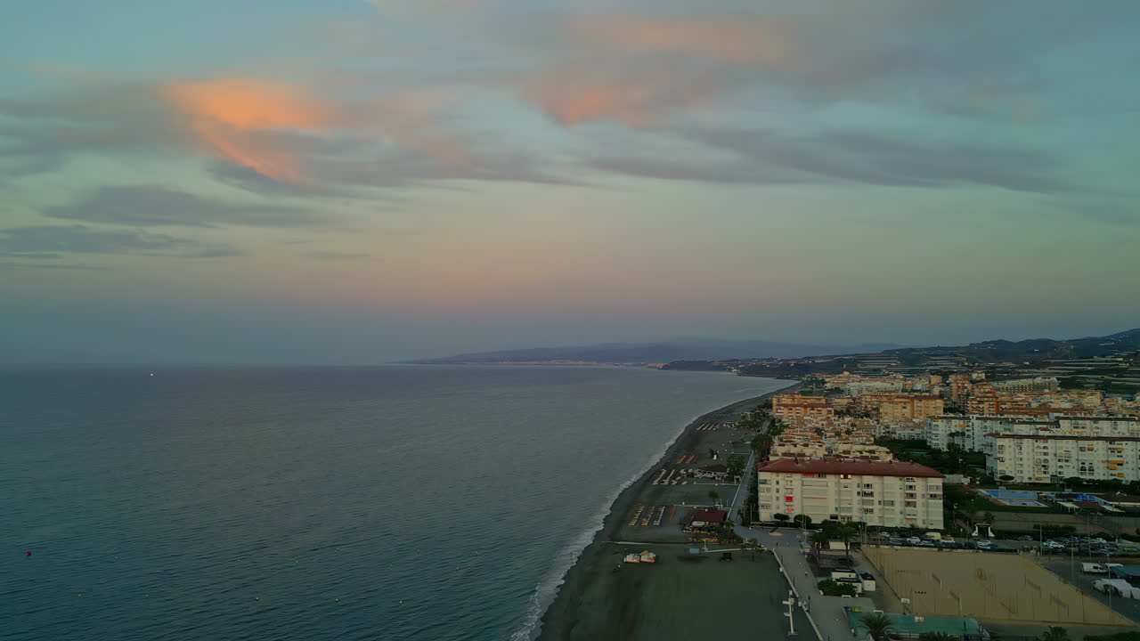 Una vista di una città costiera con l'acqua del mare che forma onde calme in Spagna.