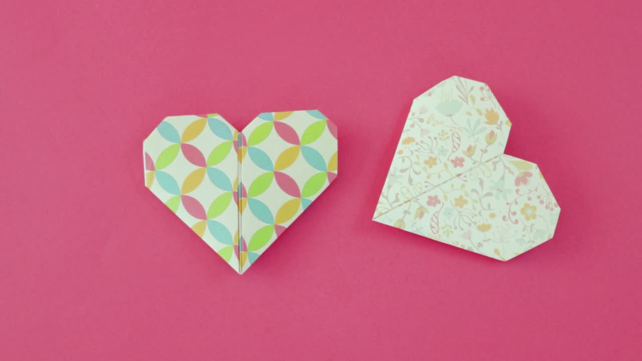 Valentine hearts made from decorative origami paper on pink paper