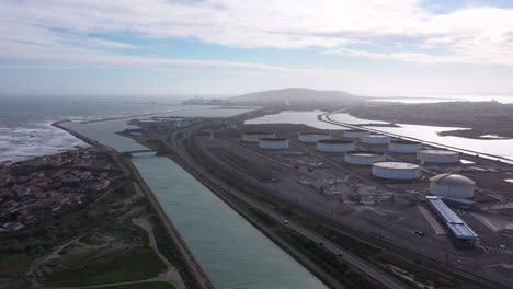 aerial de regreso viajando sobre un canal costero en el almacenamiento de gas y petróleo de frontignan.