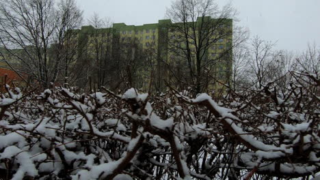 Snow-is-falling-in-the-city,-as-seen-from-a-small-playground-in-a-city-suburb